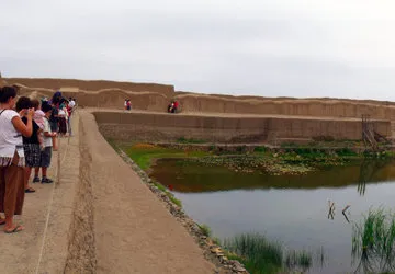 Travelers admiring a pool at the pre-Incan city of Chan Chan
