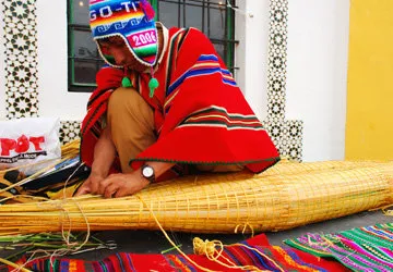 An islander from Lake Titicaca securing totora reed bundles