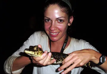 Holding a baby black caiman (Conservation Dependent)