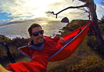 Travel selfie while relaxing riverside in hammock