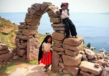Peruvian children at the stone entry arch of Taquile Island.