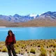 Mujer parada a orillas de laguna condoriri, Bolivia