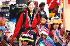 Joven rodeada de niños de Pisac, Cusco