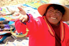 Mujer sonriente vendiendo souvenirs de la isla de los Uros