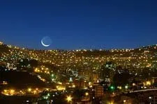 La ciudad de La Paz de noche, luces y la luna creciente