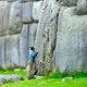 Man reposing against stones of Sacsayhuaman Fortress in Cusc