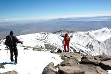 Hikers at the snow-covered crater summit of Chachani Volcano