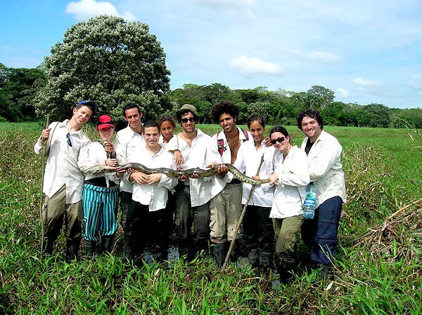 Group holding a large boa in the Bolivia marshlands near Rur