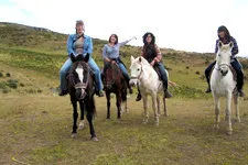 Group riding horses around the Inca ruins on the outskirts o