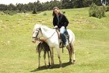 Girl riding horse around the Inca ruins on the outskirts of 
