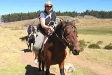 Girl riding horse along the Inca ruins in the outskirts of C