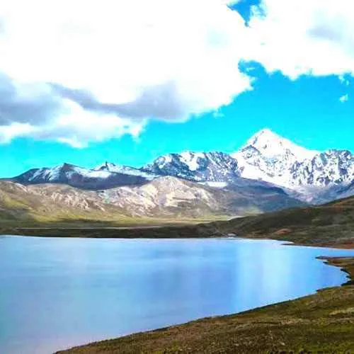 Mujer parada a orillas de laguna condoriri, Bolivia
